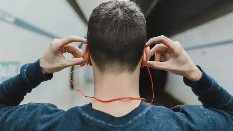 Man putting in earphones to fix audio echo on a video call