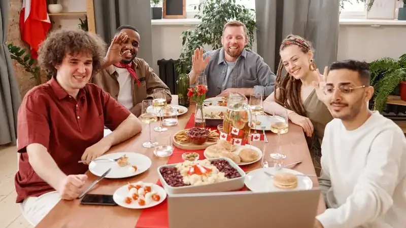 Group of friends laughing around a laptop showing positive chat culture